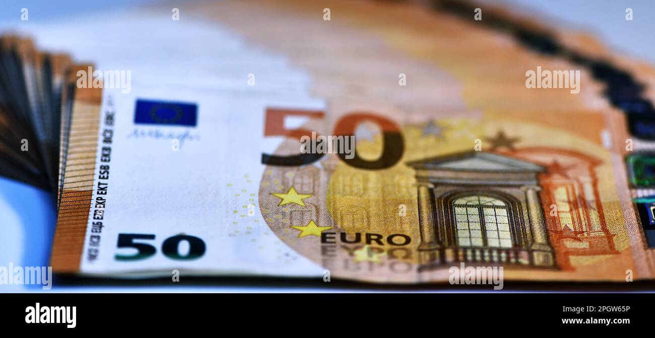 Concetto di molti euro: Un mucchio di banconote arrotolate da 50 euro giacenti su uno sfondo bianco, pila di banconote da 50 euro background commerciale Foto Stock