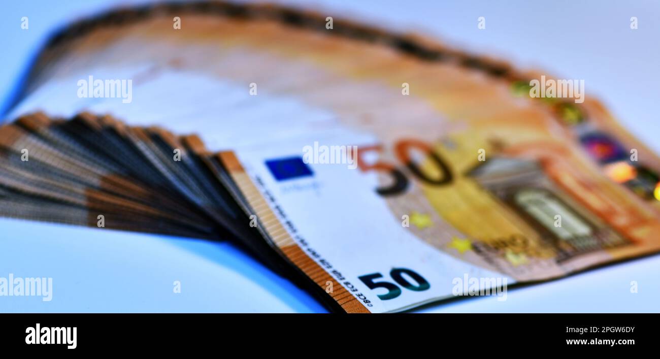 Concetto di molti euro: Un mucchio di banconote arrotolate da 50 euro giacenti su uno sfondo bianco, pila di banconote da 50 euro background commerciale Foto Stock