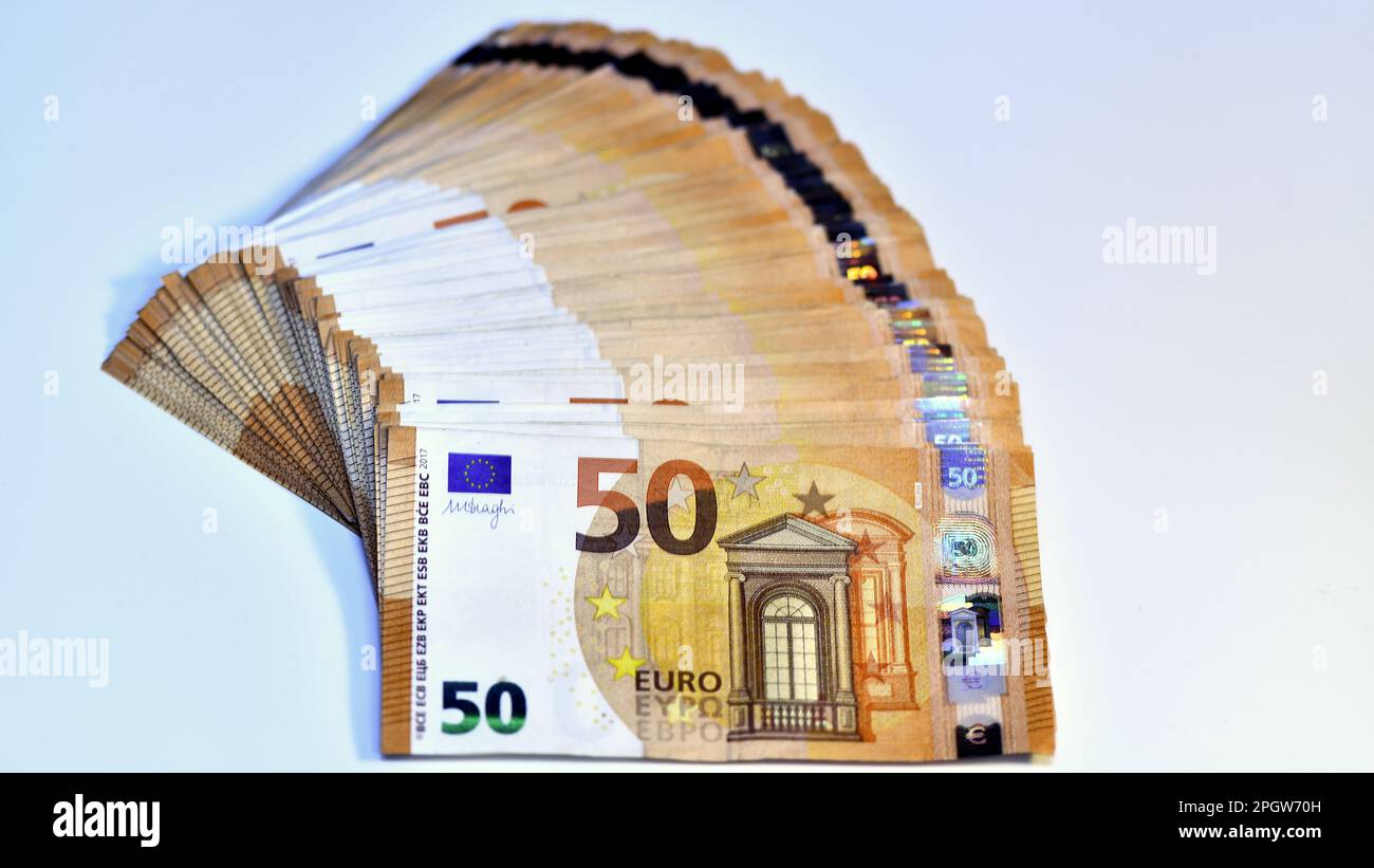 Concetto di molti euro: Un mucchio di banconote arrotolate da 50 euro giacenti su uno sfondo bianco, pila di banconote da 50 euro background commerciale Foto Stock