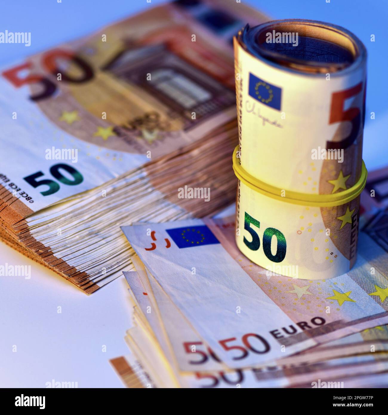 Concetto di molti euro: Un mucchio di banconote arrotolate da 50 euro giacenti su uno sfondo bianco, pila di banconote da 50 euro background commerciale Foto Stock