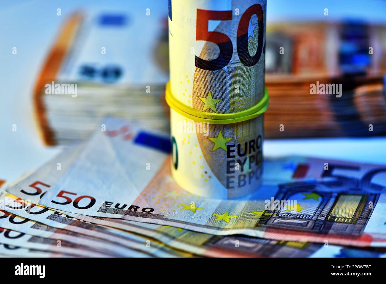 Concetto di molti euro: Un mucchio di banconote arrotolate da 50 euro giacenti su uno sfondo bianco, pila di banconote da 50 euro background commerciale Foto Stock