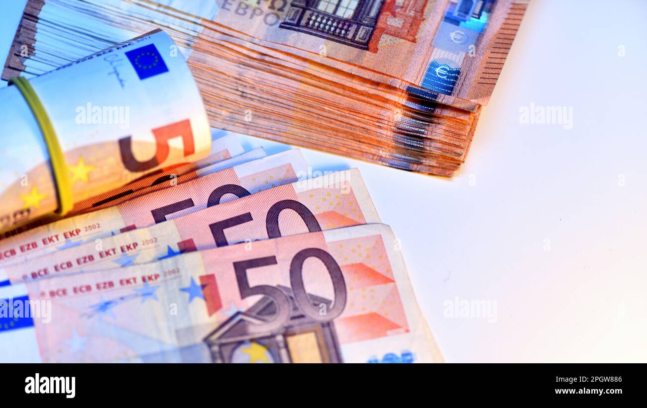 Concetto di molti euro: Un mucchio di banconote arrotolate da 50 euro giacenti su uno sfondo bianco, pila di banconote da 50 euro background commerciale Foto Stock