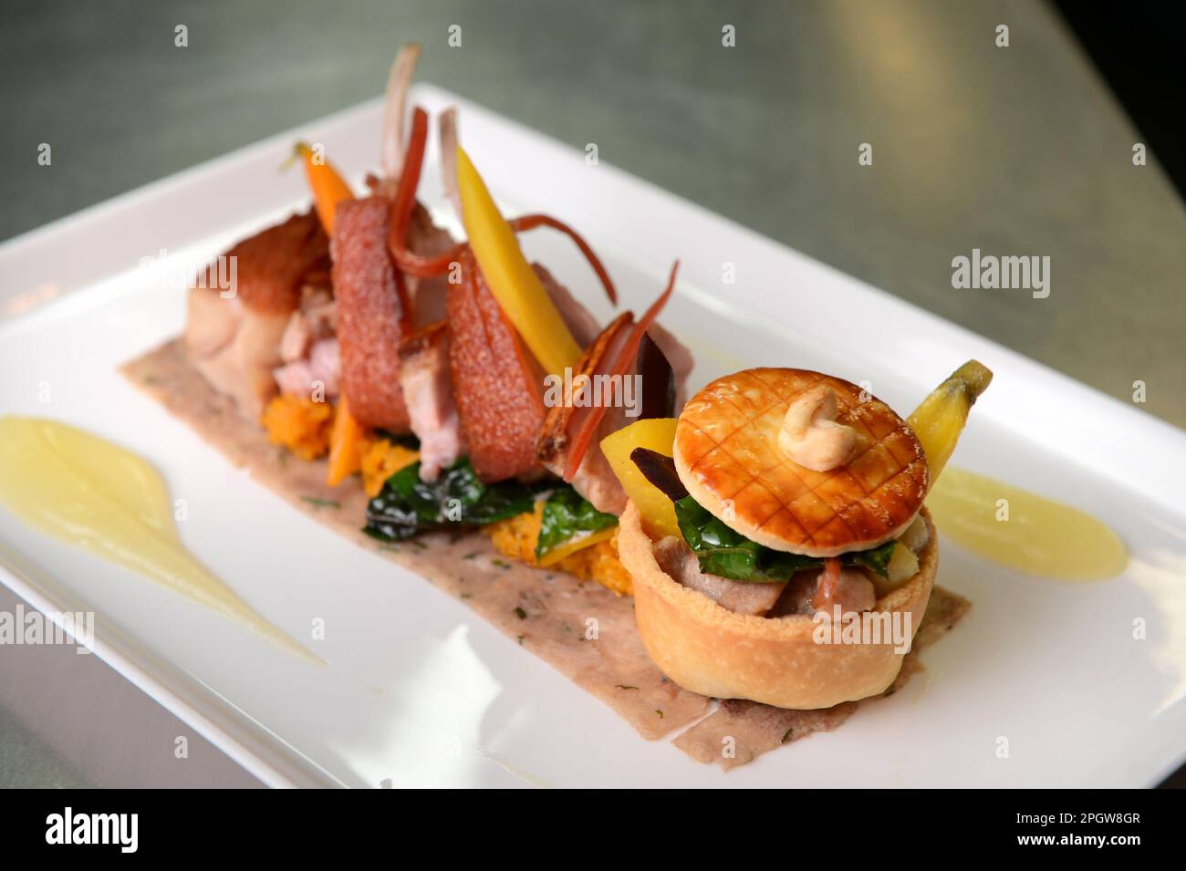 Una moderna versione del pranzo domenicale il piatto arrosto succhietto Pig con carota Quinoa al Feathered Nest in Oxfordshire. Foto Stock