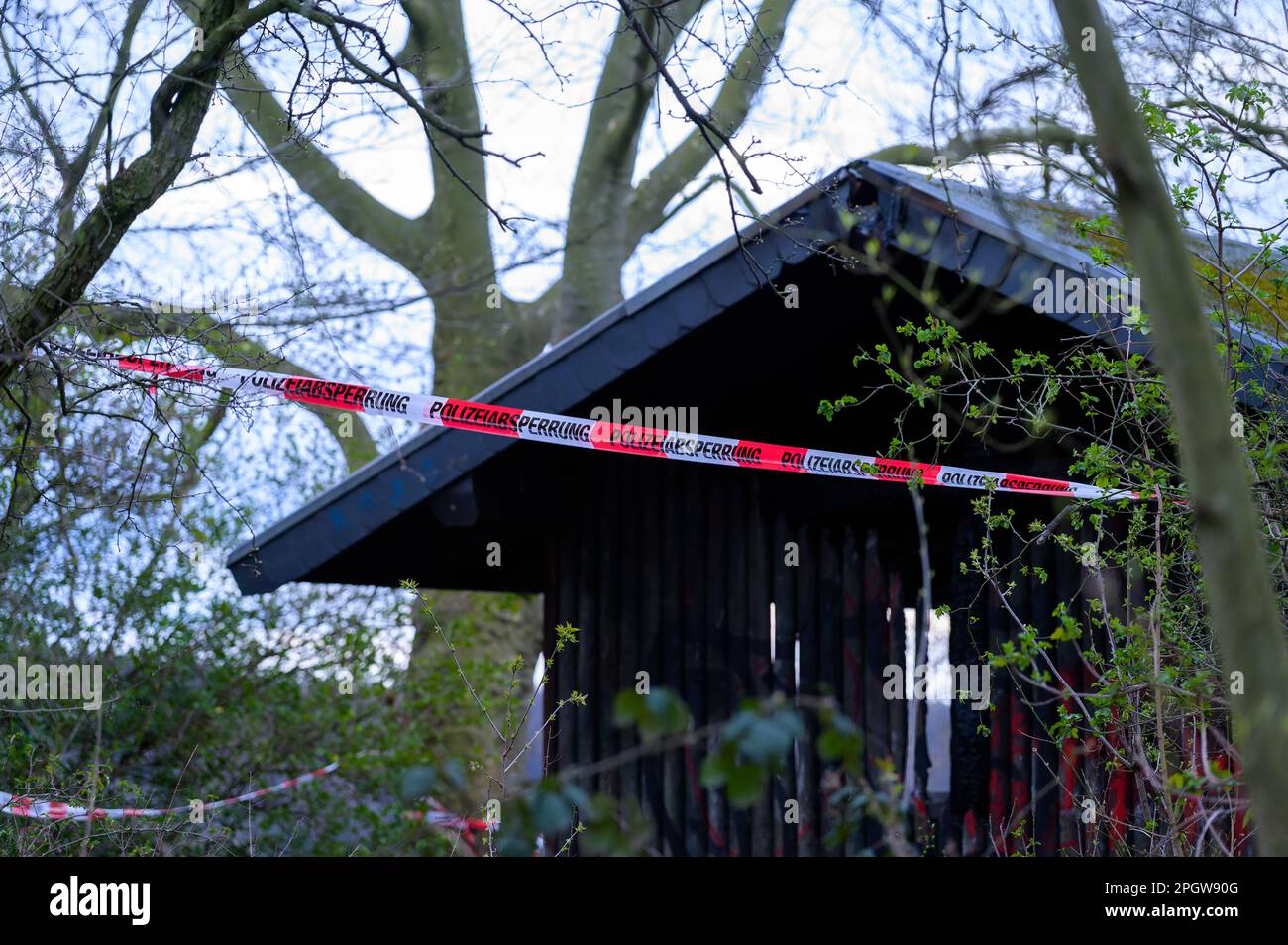 Una capanna di legno in un parco pubblico è incoronata da un nastro di scena criminale della polizia Foto Stock