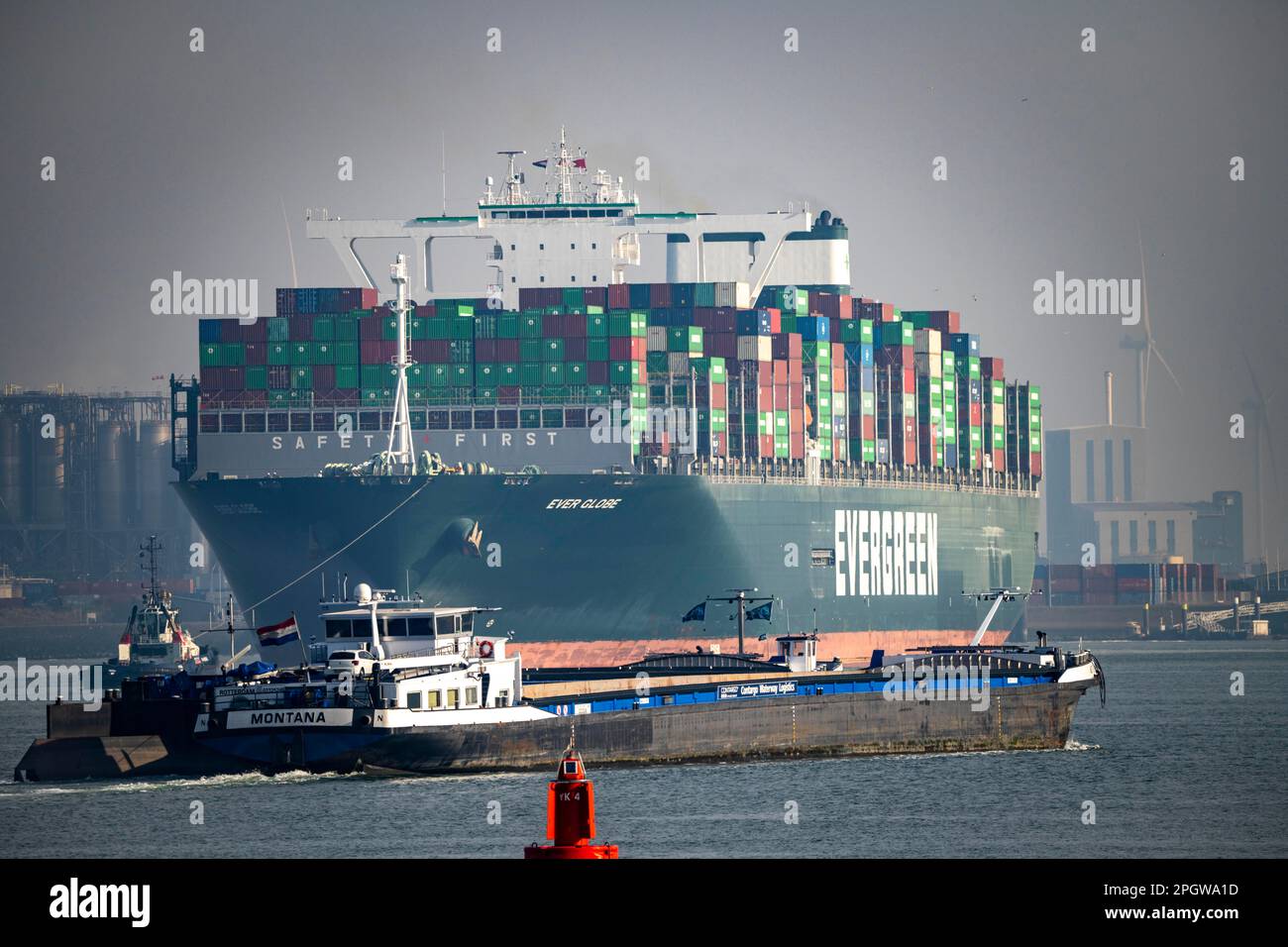 I rimorchiatori portano il container freighter Ever Globe al suo ormeggio a Hutchison Ports ECT Euromax, sul Yangtzekanaal su Maasvlakte 2, Rotterdam, Th Foto Stock