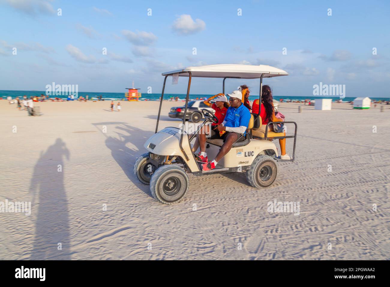 Miami, USA - 30 agosto 2014: Le persone in un'auto elettrica da spiaggia guidano lungo la spiaggia sud nel tardo pomeriggio. La spiaggia sud è aperta per auto elettriche, bicycl Foto Stock