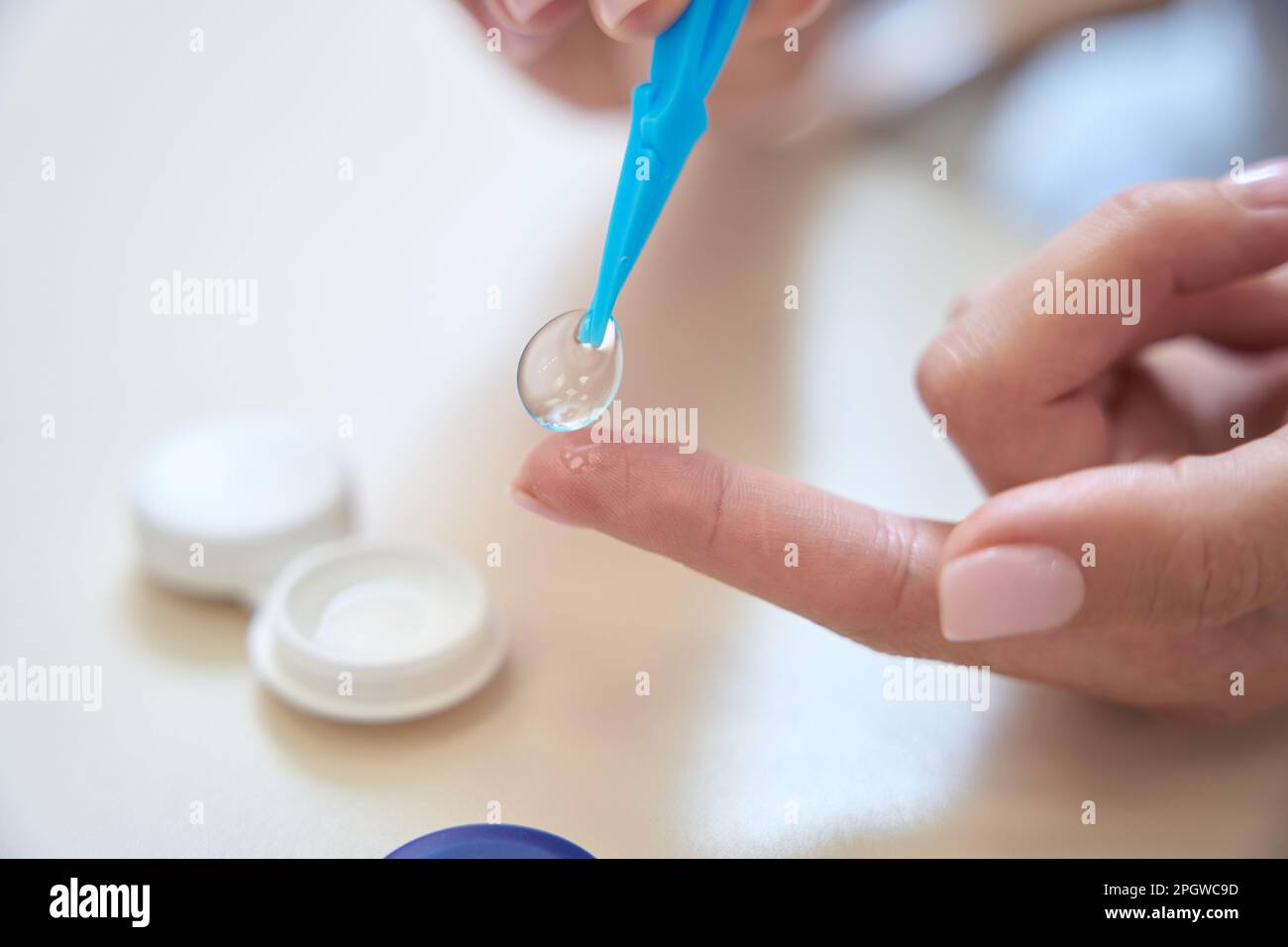 Mano da dottore femmina che tiene lenti monouso trasparenti Foto Stock