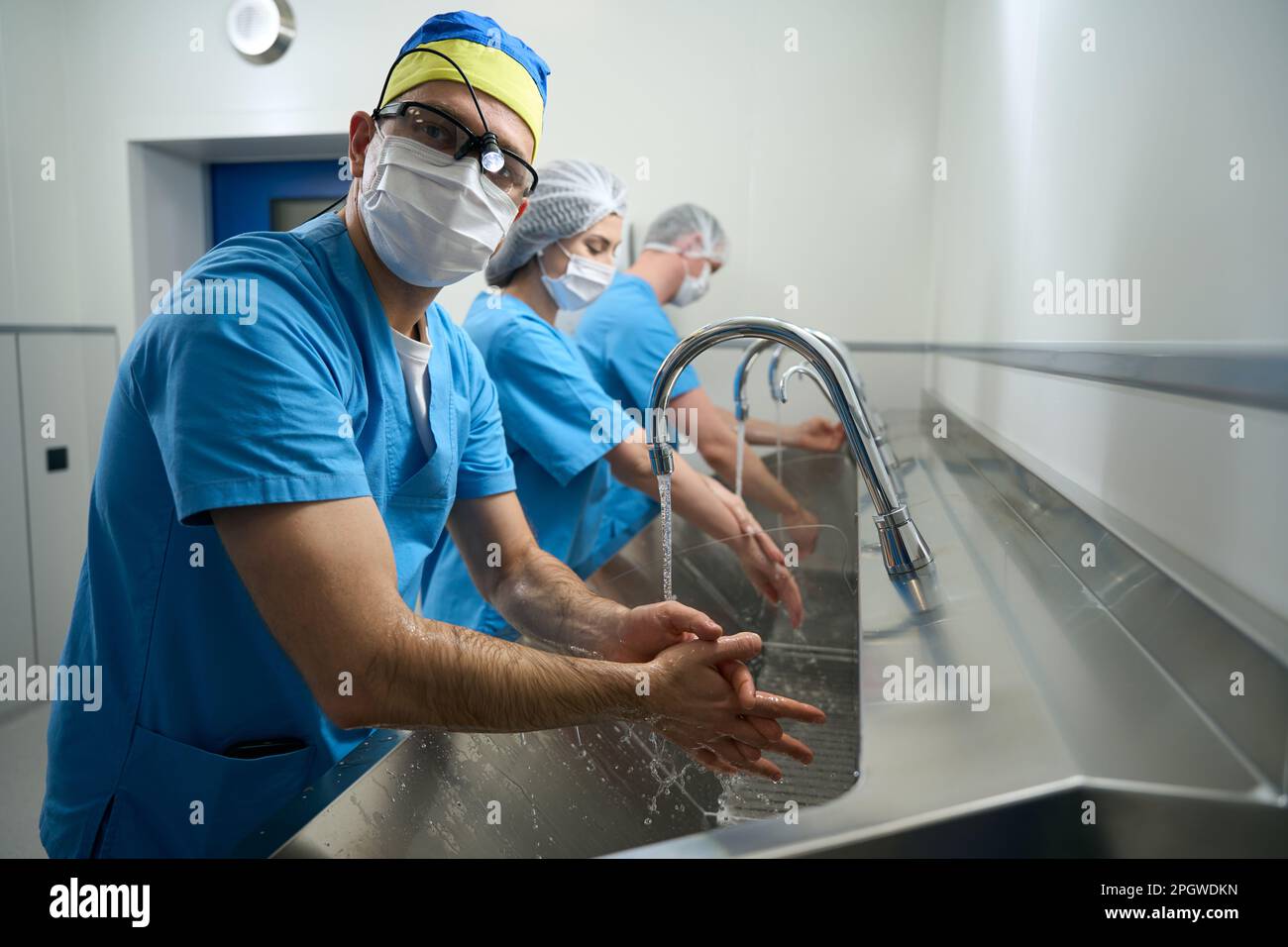Le persone in camici medici si lavano le mani prima dell'intervento Foto Stock