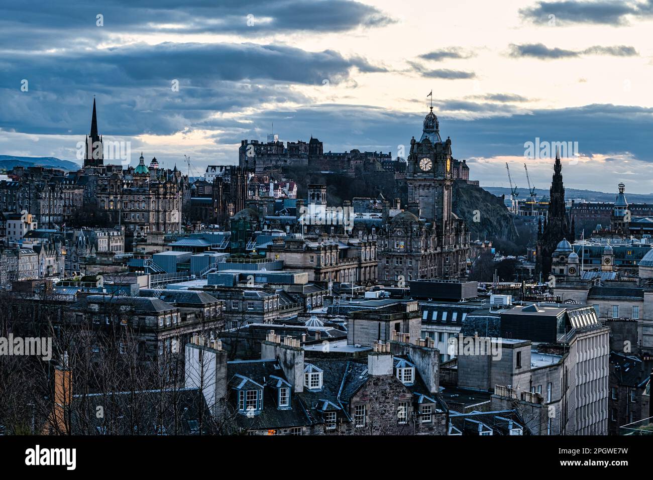 Vista sui tetti del centro città al tramonto con la torre dell'orologio Balmoral e il castello di Edimburgo, Scozia, Regno Unito Foto Stock