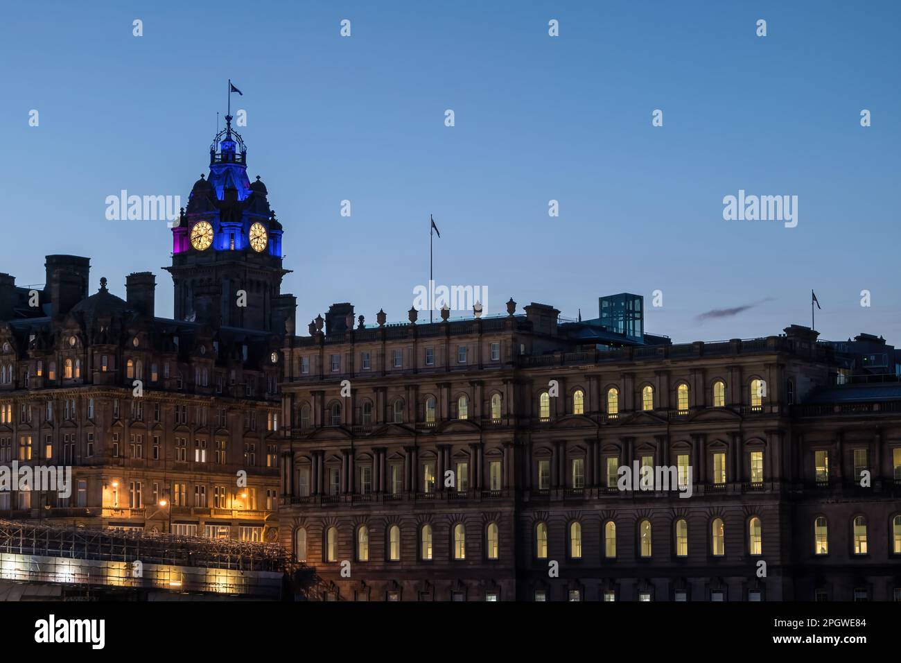 La torre dell'orologio del Balmoral Hotel, illuminata al crepuscolo o al crepuscolo con un cielo limpido, Edimburgo, Scozia, Regno Unito Foto Stock