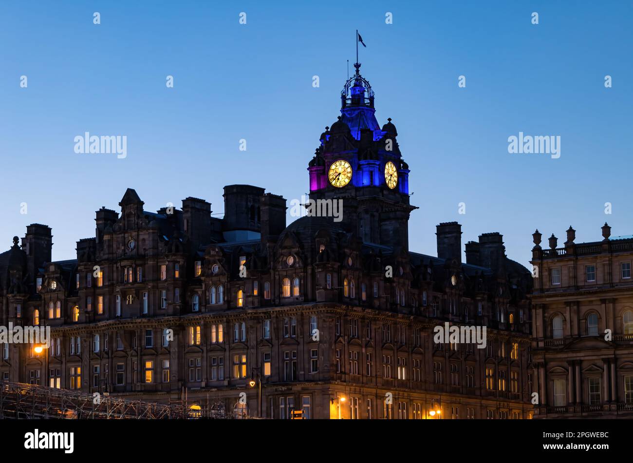 La torre dell'orologio del Balmoral Hotel, illuminata al crepuscolo o al crepuscolo con un cielo limpido, Edimburgo, Scozia, Regno Unito Foto Stock