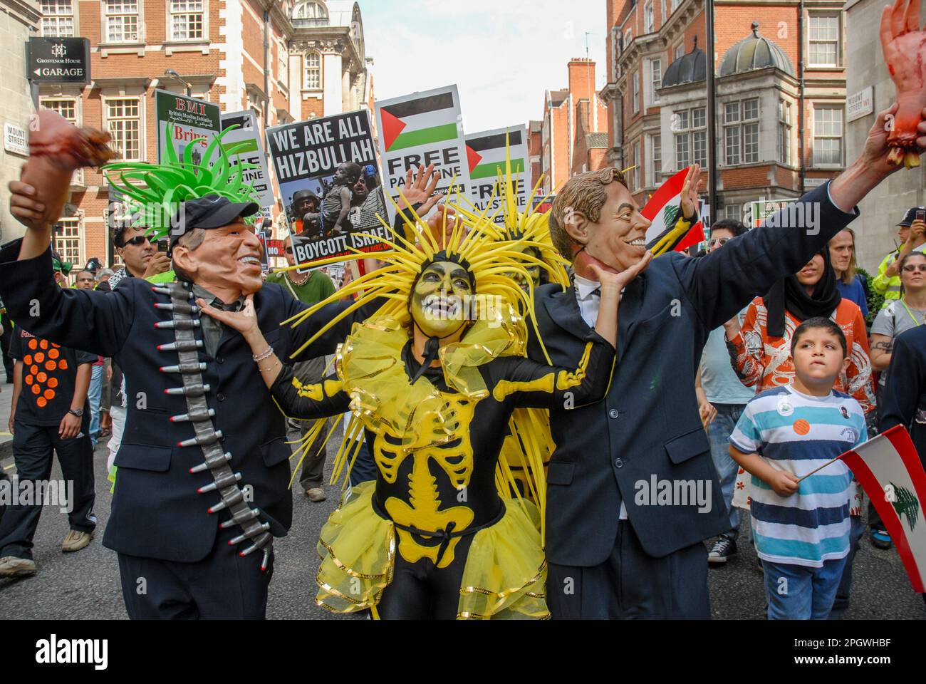 Protesta contro la guerra di Israele Libano 2006, Londra UK. I manifestanti mascherati di Bush e Blair ballano con scheletro, con Hezbollah e cartelli palestinesi Foto Stock