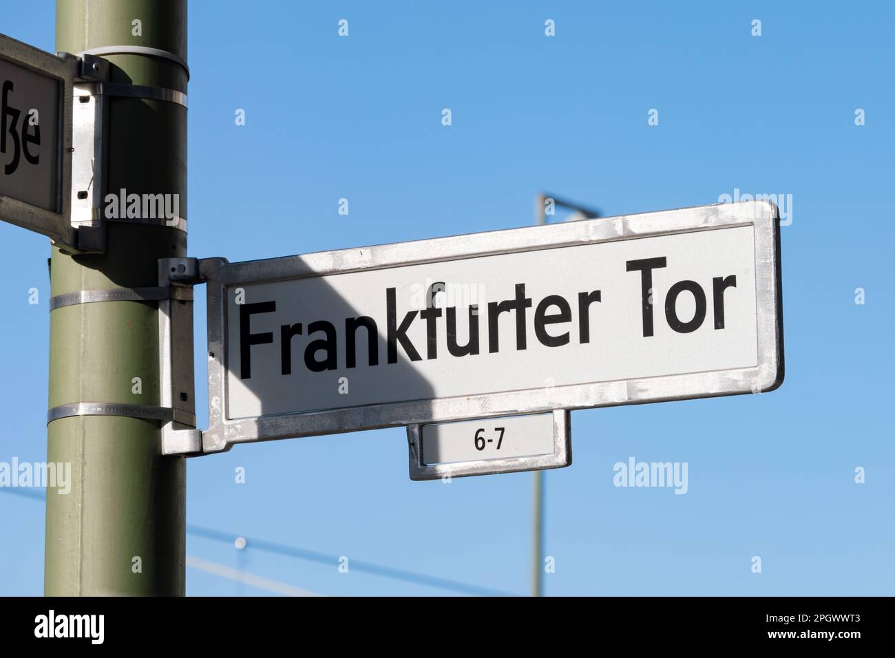 Frankfurter Tor, cartello con il nome della strada a Berlino Friedrichshain. Telaio in metallo con una piastra bianca all'interno. Le lettere sono stampate in nero sulla targhetta. Foto Stock