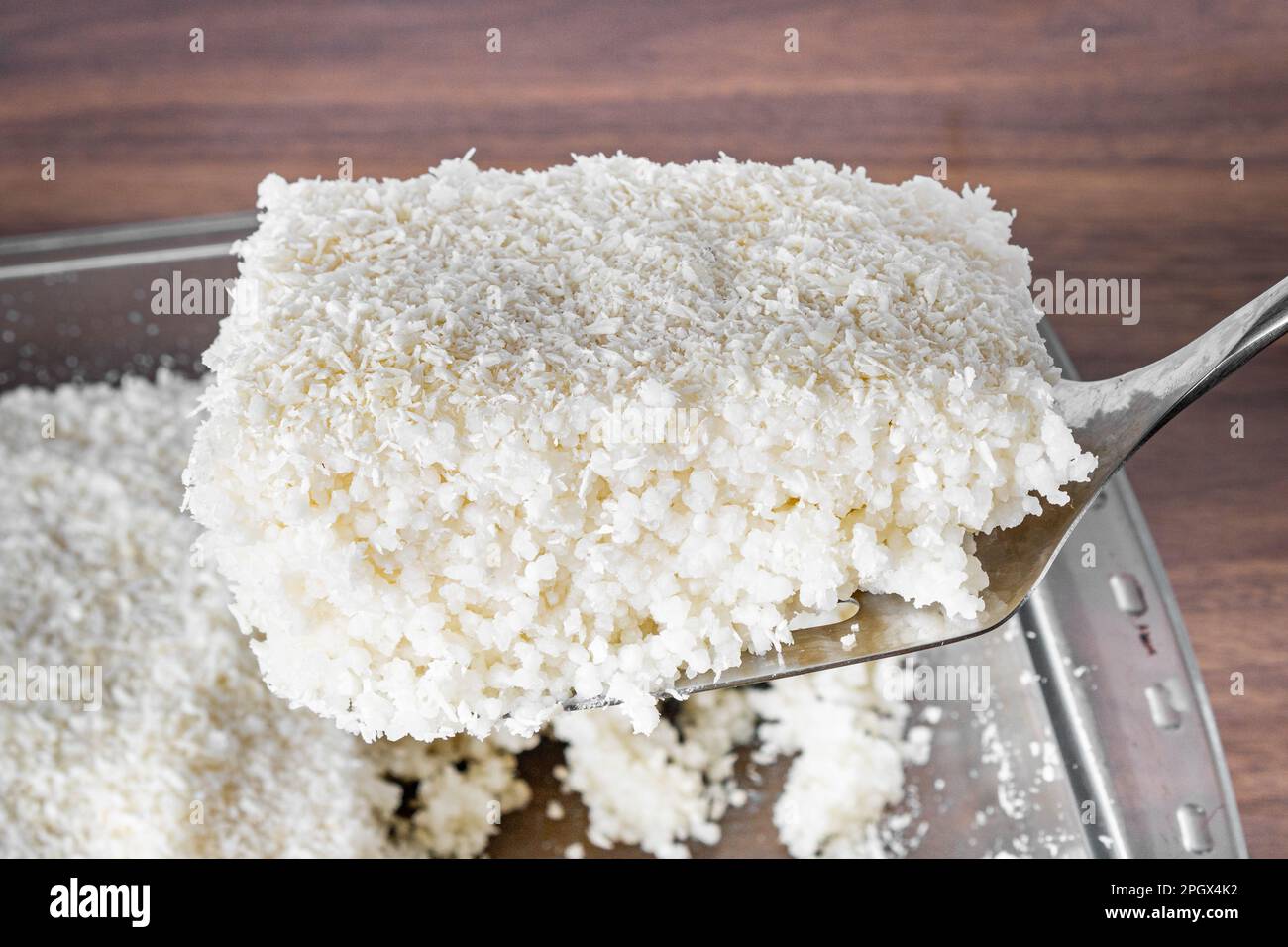 Couscous ciotola, piatto tipico brasiliano, a base di tapioca, latte, zucchero e latte di cocco. Tagliare da un pezzo. Foto Stock