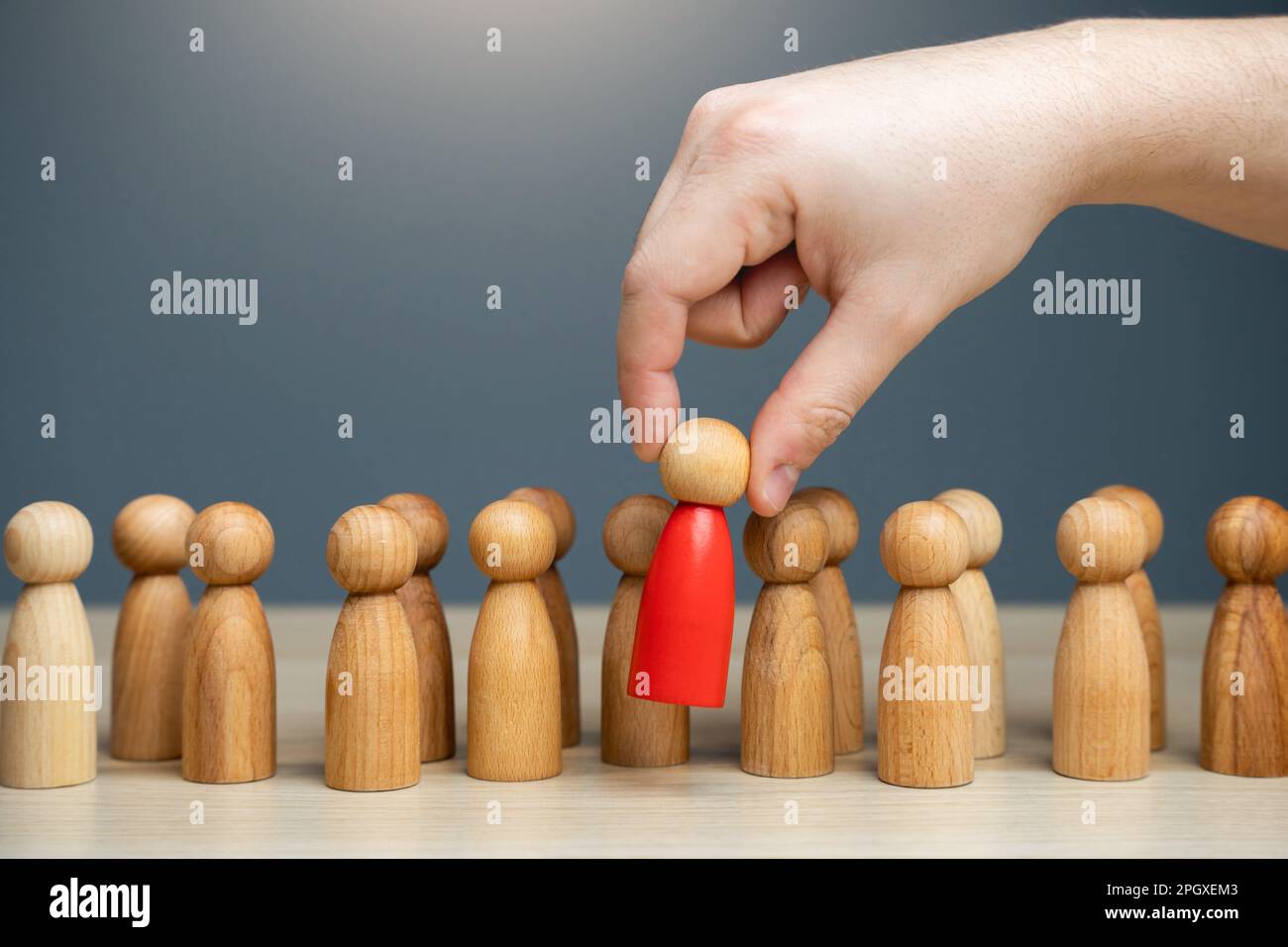 La mano seleziona una persona rossa dalla folla. Assunzione e reclutamento per lavoro. Trova la persona che stai cercando. Spie e funzionari corrotti. Inculo Foto Stock