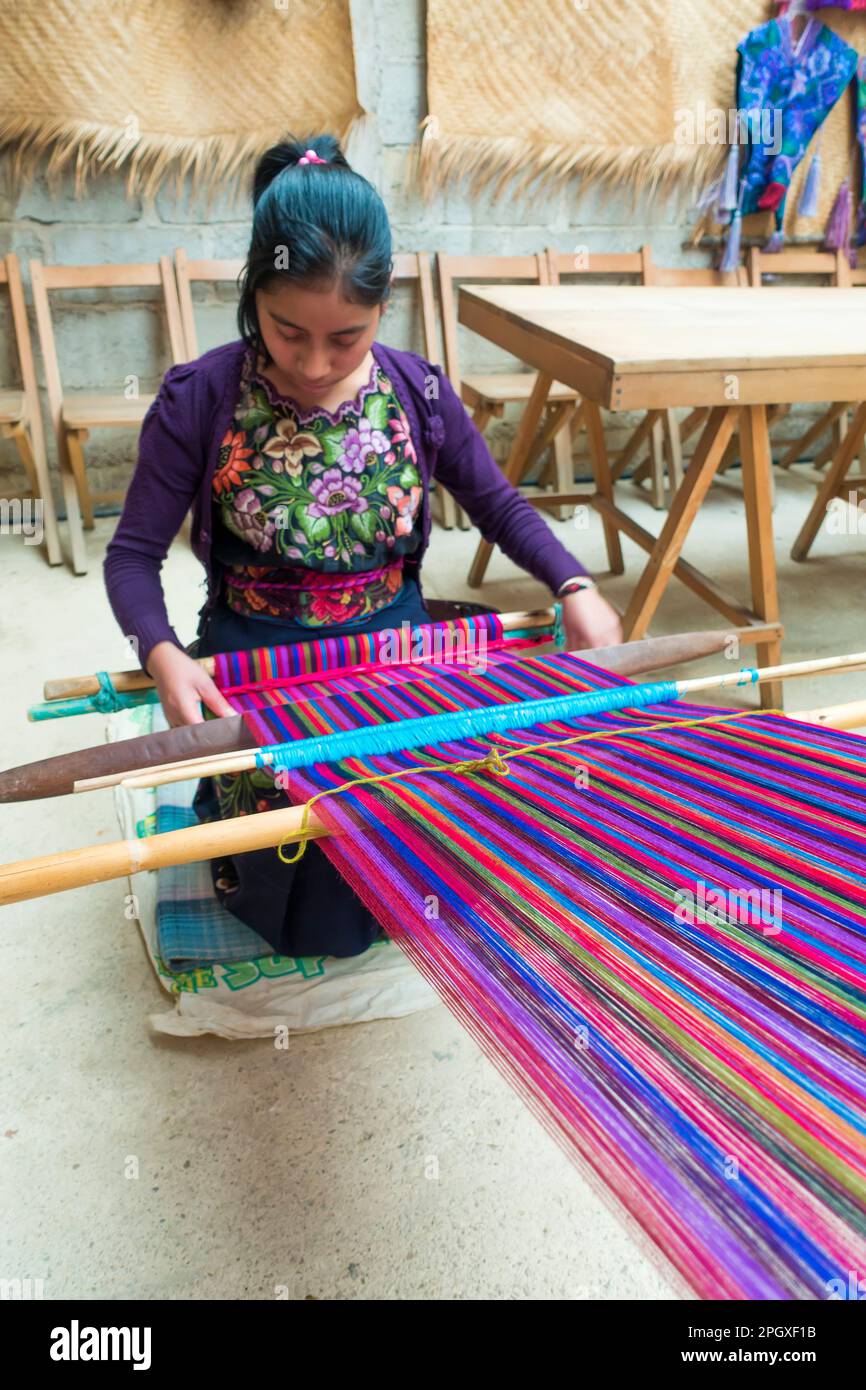 Giovane donna tesse tessuti in Guatemala, America Centrale Foto Stock