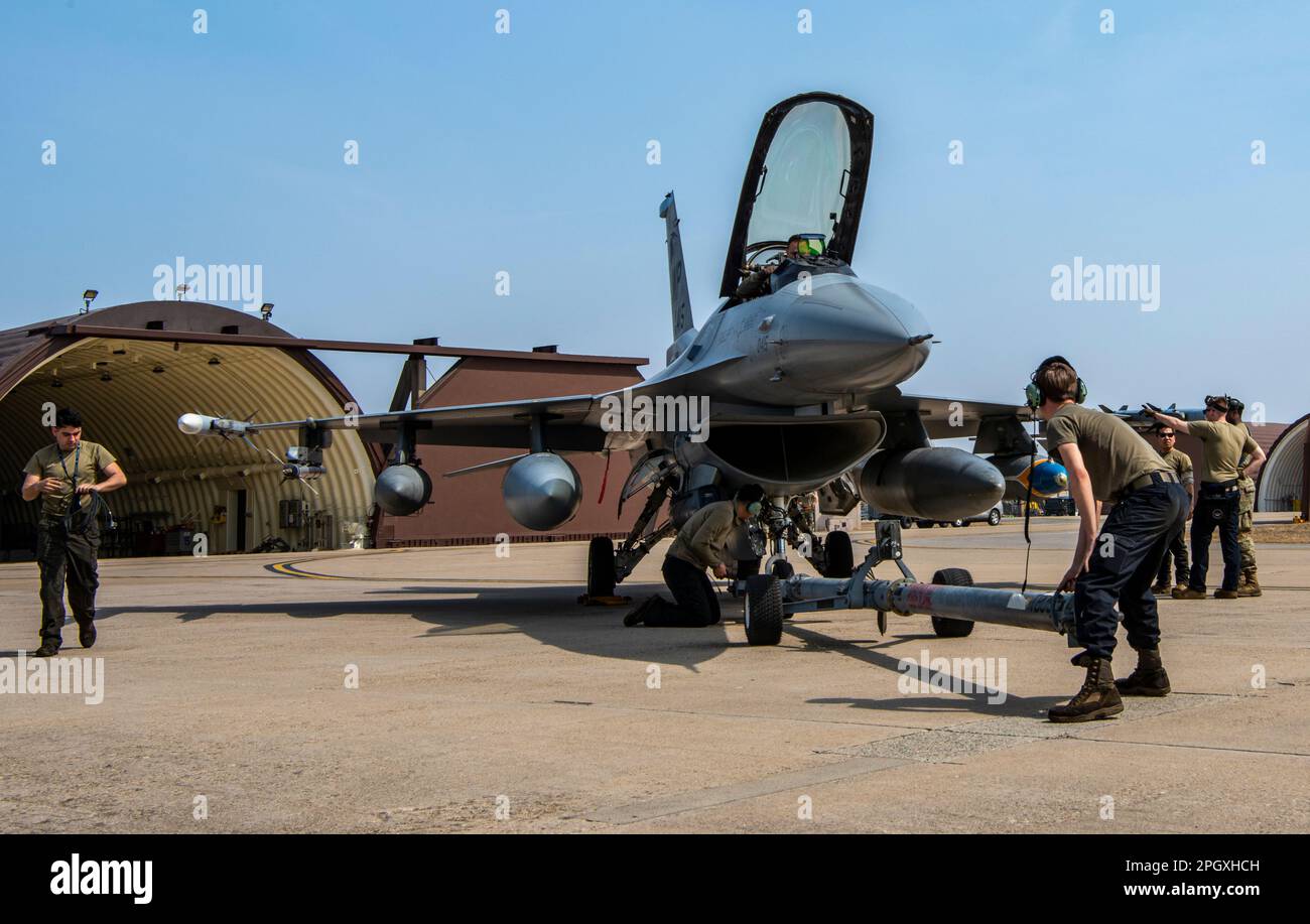 STATI UNITI Air Force Airmen assegnato al 35th Fighter Generation Squadron, Kunsan Air base, si preparano a trainare un F-16 Fighting Falcon a Osan AB, Repubblica di Corea, 22 marzo 2023. L'aereo si è temporaneamente riposizionato in Osan AB mentre la loro linea di volo è sottoposta a importanti riparazioni infrastrutturali. (STATI UNITI Foto dell'Aeronautica militare di staff Sgt. Dwane R. Young) Foto Stock