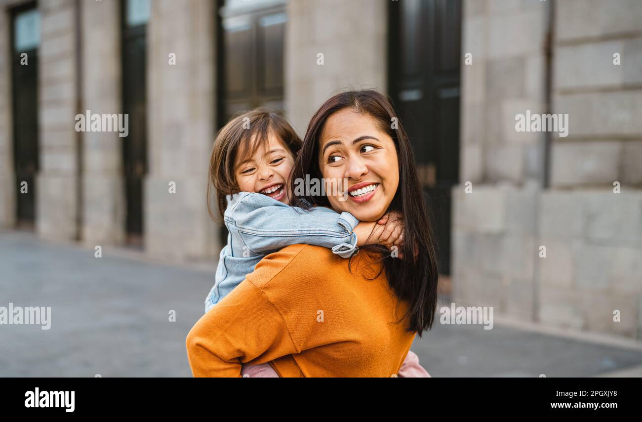 Felice madre del sud-est asiatico con sua figlia che si diverte nel centro della città - bella famiglia all'aperto Foto Stock