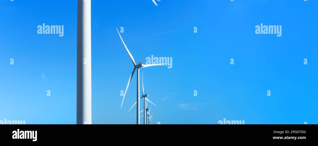 Fila di turbine eoliche, sfondo cielo blu. Banner con molte turbine eoliche. Energia verde, elettricità ecologica, risorse rinnovabili, Foto Stock