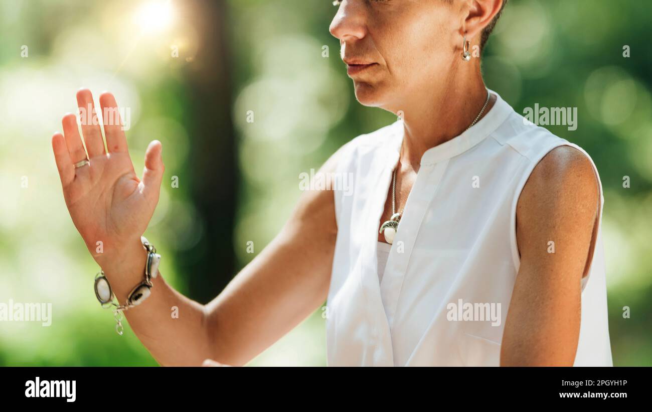 Donna che pratica il qigong in una foresta Foto Stock