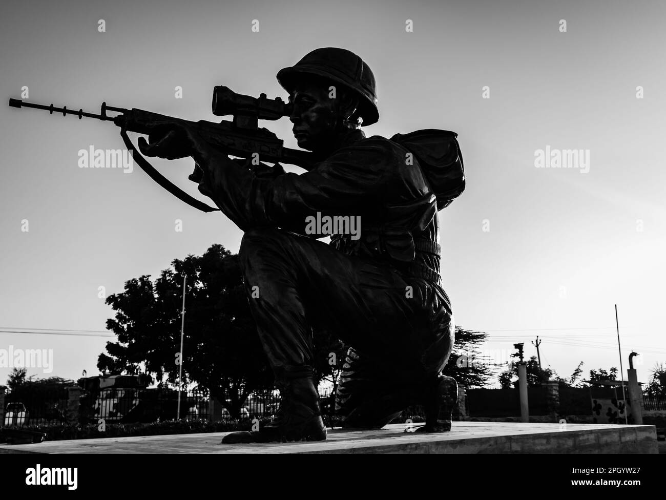 soldato isolato retro illuminato statua con pistola e cielo drammatico da diverse angolazioni alla sera Foto Stock