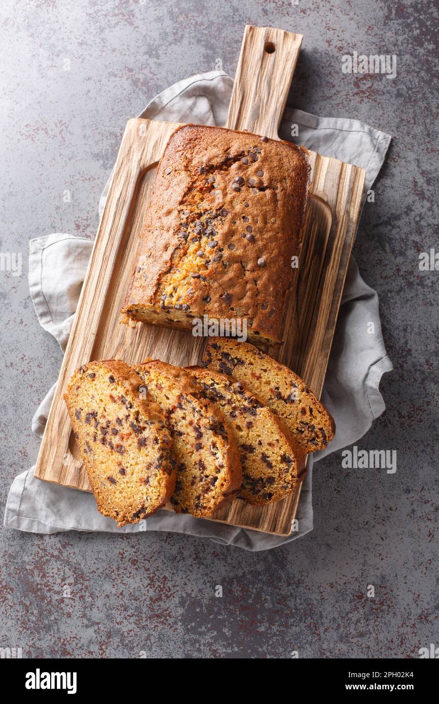 Pane di zucca con scaglie di cioccolato fatto in casa tagliare a fette il primo piano sulla tavola di legno sul tavolo. Vista verticale dall'alto Foto Stock