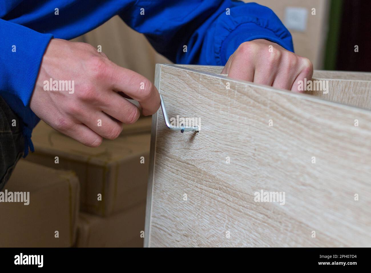 Uomo che monta il fissaggio di mobili con una chiave esagonale Foto Stock