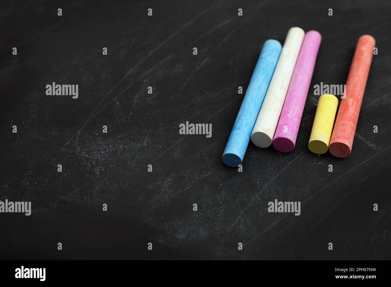 Gessi colorati su lavagna nera, spazio per il testo Foto stock - Alamy