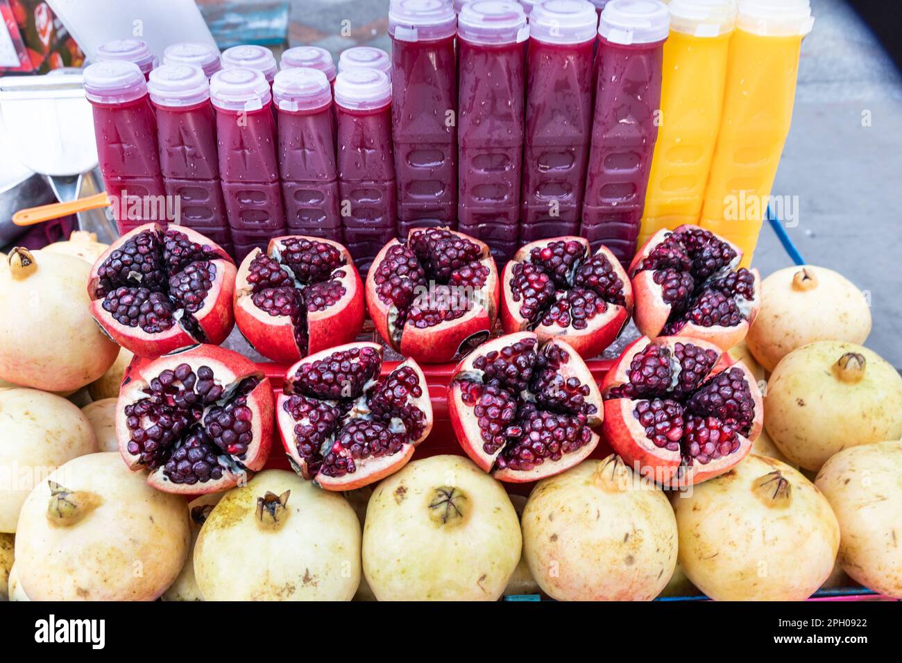 La frutta di melograno dimezzata rivelando i relativi arils o semi e il succo in bottiglia è uno del alimento eccellente popolare alto in anti-ossidante Foto Stock