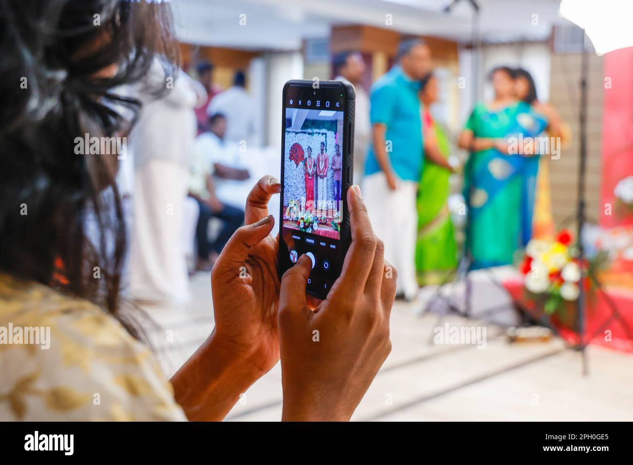 Ospite femmina che scatta foto con il telefono cellulare a Engagement Party in Hotel Shaans, Trichy, Tamil Nadu, India Foto Stock