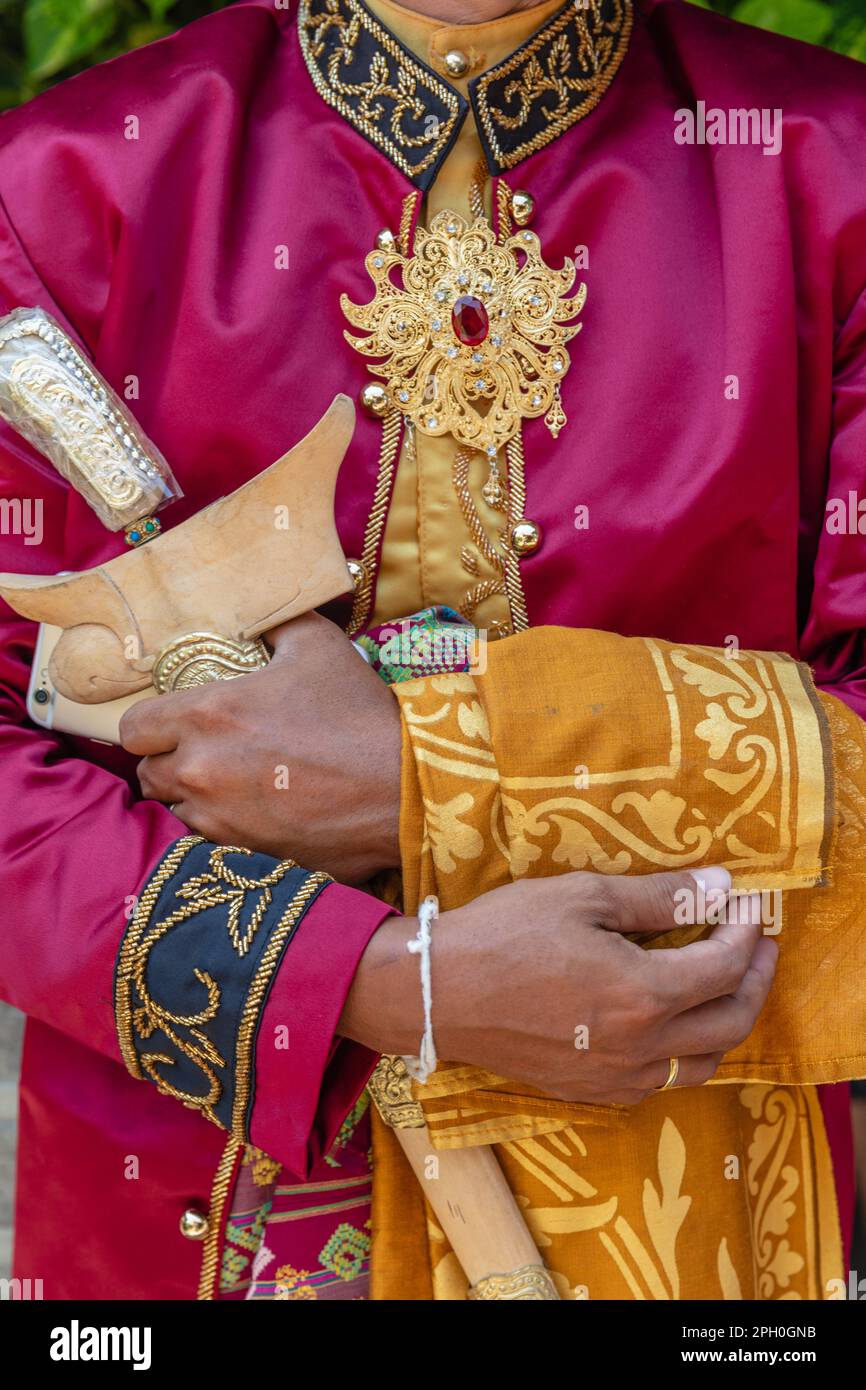 Tradizionale abito da sposa balinese maschio, gioielli d'oro e un coltello cerimoniale kris. Bali, Indonesia. Foto Stock
