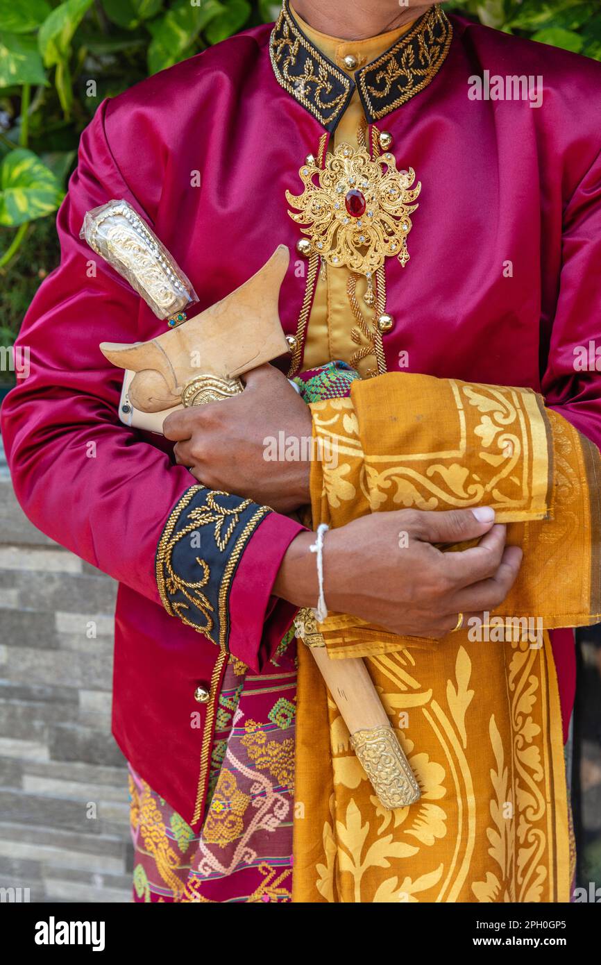 Tradizionale abito da sposa balinese maschio, gioielli d'oro e un coltello cerimoniale kris. Bali, Indonesia. Foto Stock