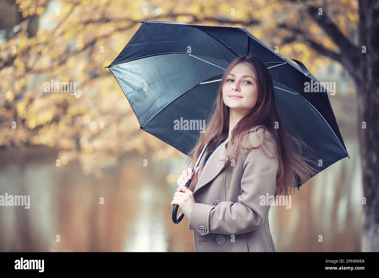 Giovane ragazza in un cappotto in autunno park Foto Stock