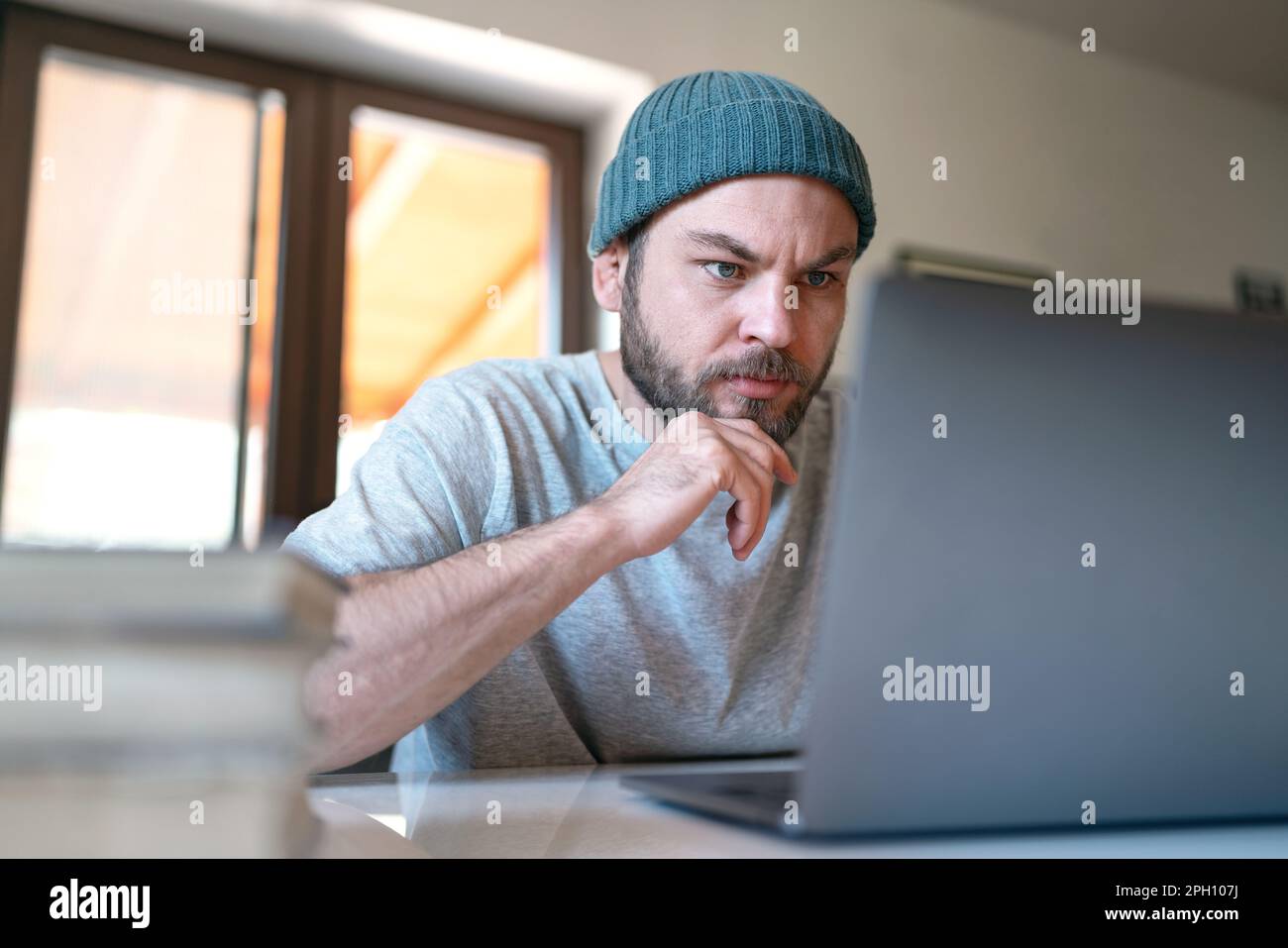 Giovane imprenditore moderno che lavora sul suo laptop a casa. Foto Stock