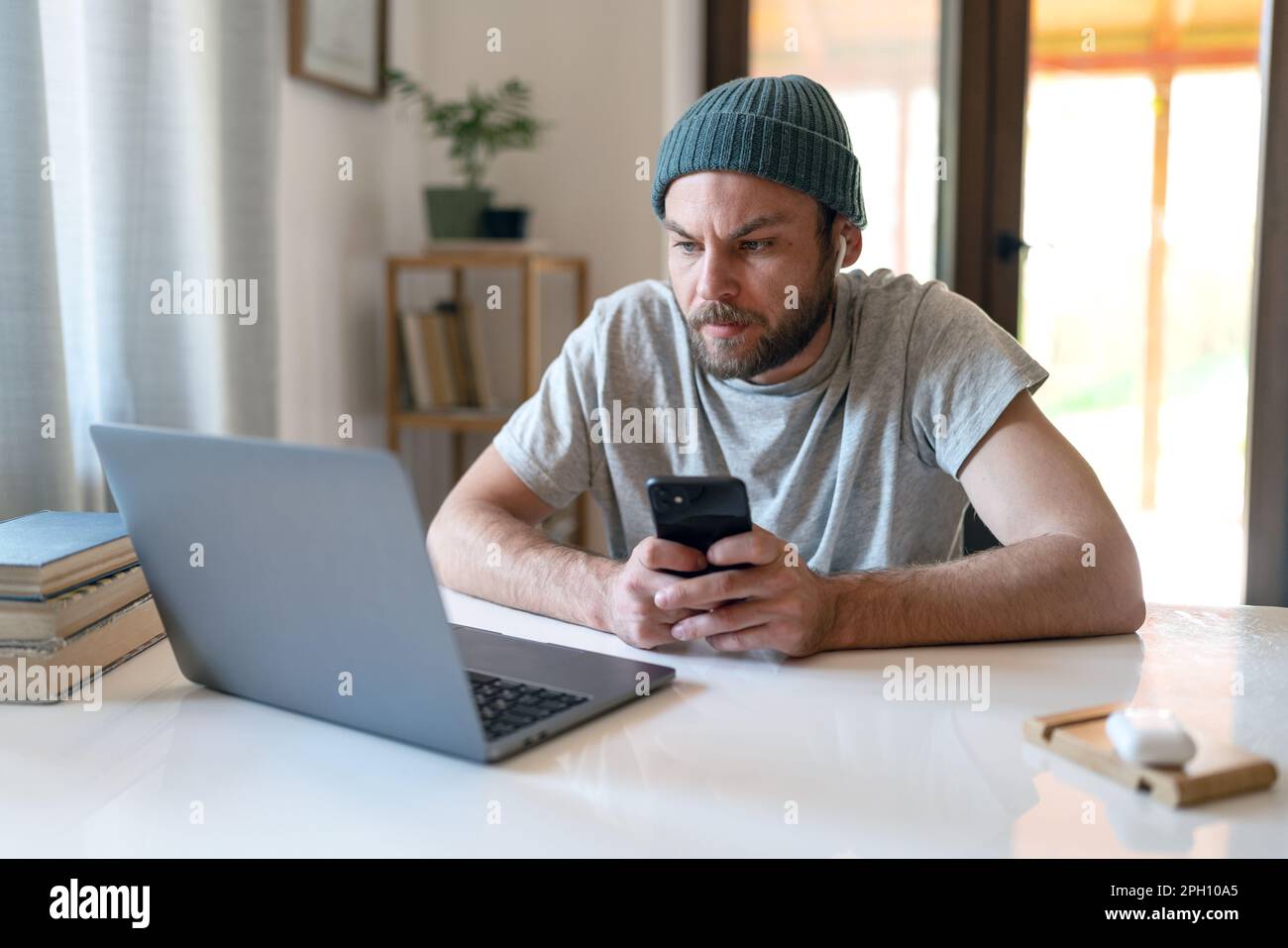 Uomo moderno che utilizza dispositivi portatili wireless a casa. Foto Stock