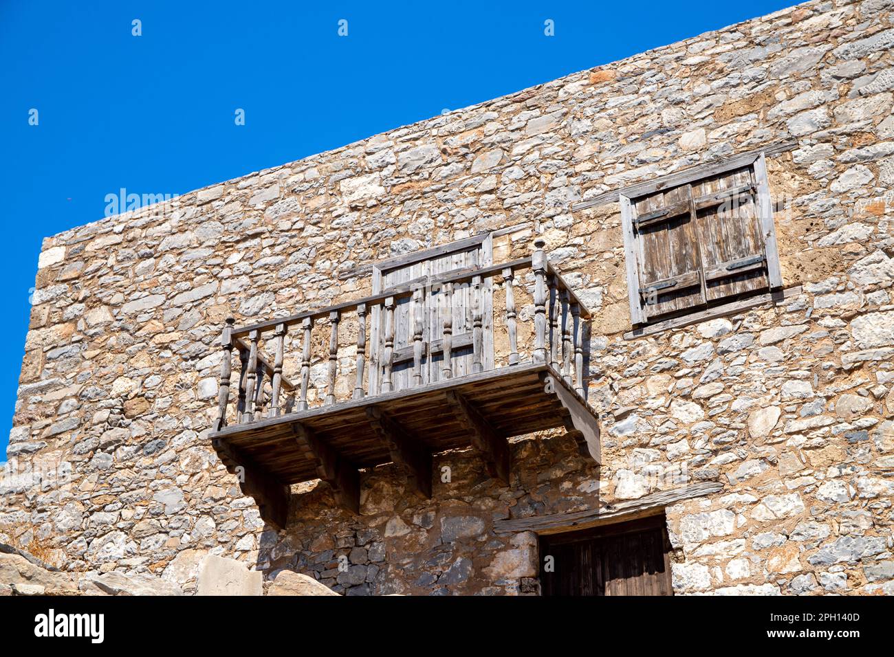 Balcone in legno su una vecchia casa in pietra. Foto di alta qualità Foto Stock