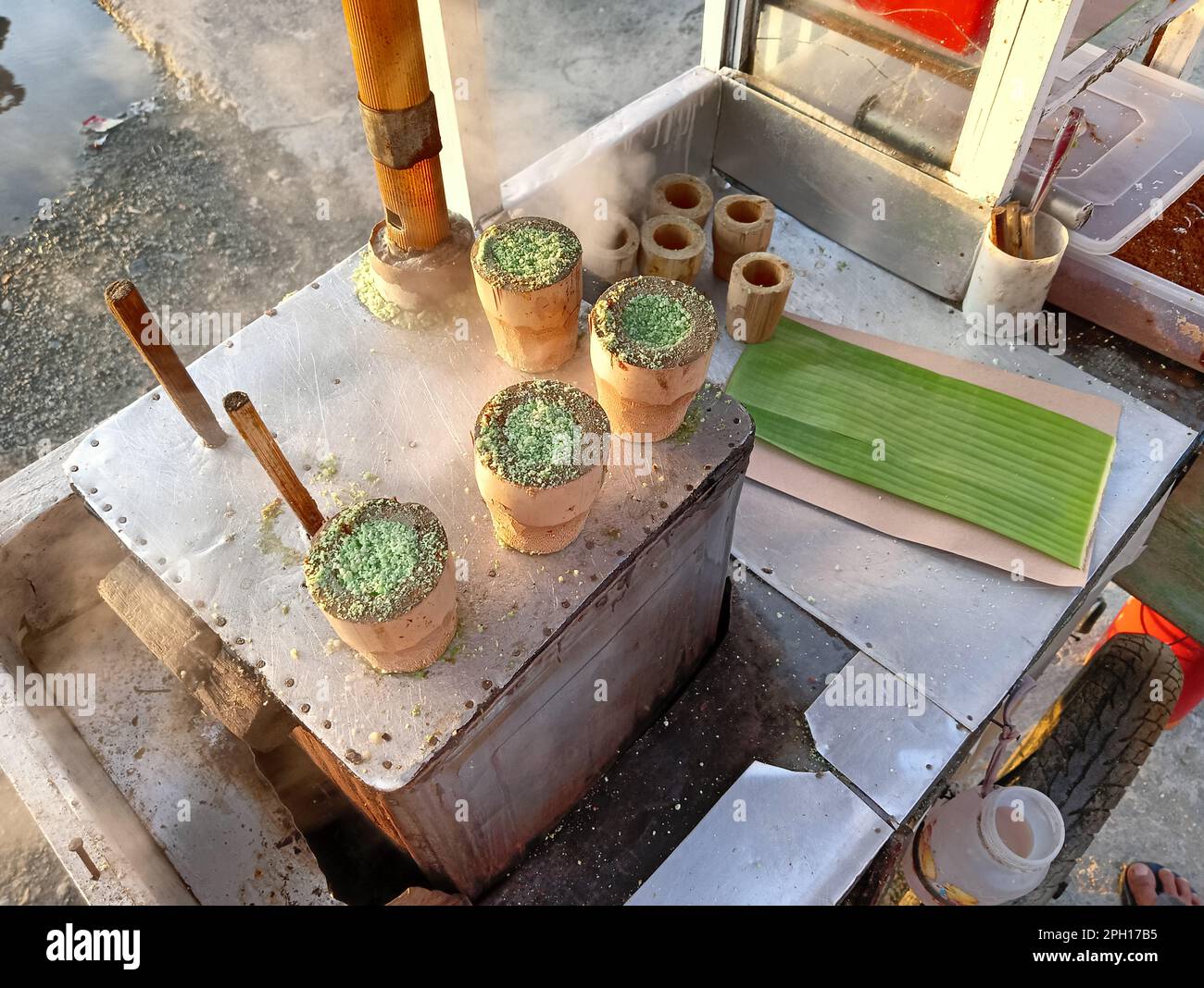 La torta Putu è un tipo di spuntino tradizionale indonesiano in forma di torta riempita con zucchero di palma, ricoperta di cocco grattugiato e riso a grani grossi fl Foto Stock