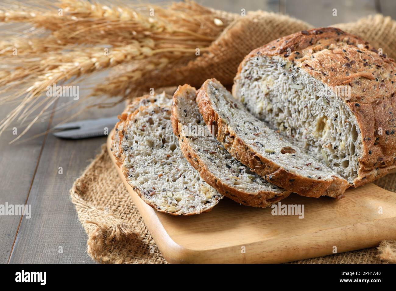 Affettato Multi grano sourdough su piastra di legno con riso Barley, concetto di panetteria fatta in casa. Foto Stock