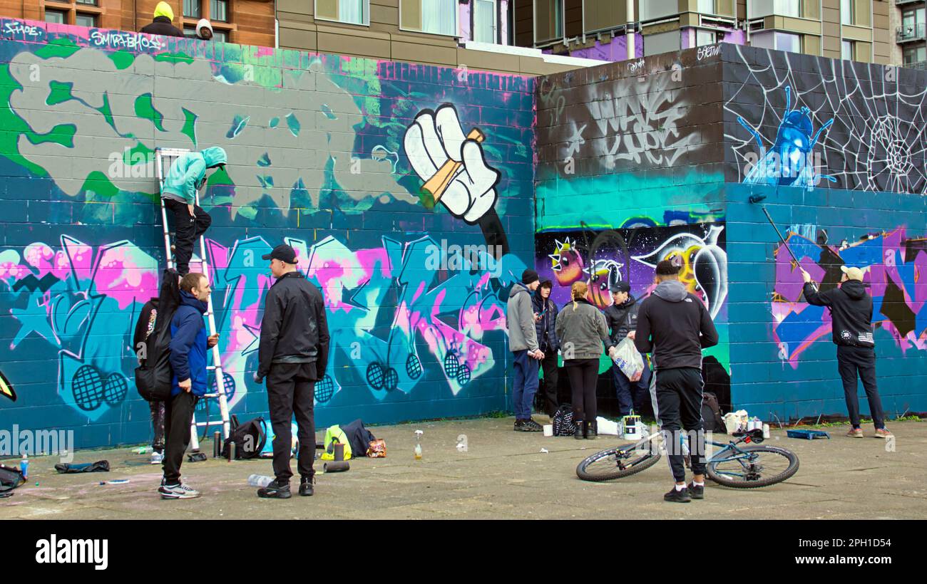 Glasgow, Scozia, Regno Unito 25tht marzo 2023. La ristrutturazione dei graffiti della passerella Clyde ha visto il sentiero coperto d'arte accanto al fiume dipinto mentre i guerrieri della bomba spray rivale ricoprono le loro opere d'arte rivali mentre i turisti bemused guardano. Credit Gerard Ferry/Alamy Live News Foto Stock