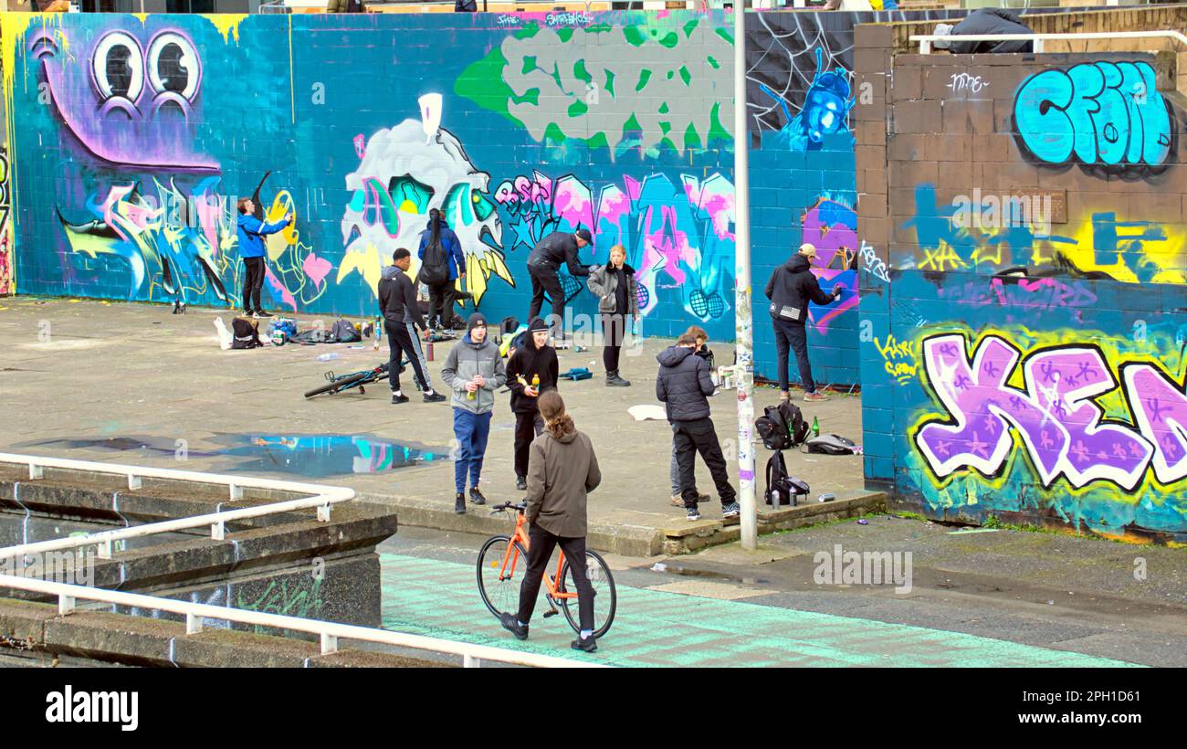 Glasgow, Scozia, Regno Unito 25tht marzo 2023. La ristrutturazione dei graffiti della passerella Clyde ha visto il sentiero coperto d'arte accanto al fiume dipinto mentre i guerrieri della bomba spray rivale ricoprono le loro opere d'arte rivali mentre i turisti bemused guardano. Credit Gerard Ferry/Alamy Live News Foto Stock