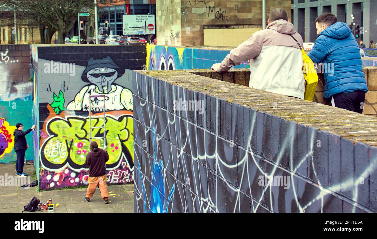 Glasgow, Scozia, Regno Unito 25tht marzo 2023. La ristrutturazione dei graffiti della passerella Clyde ha visto il sentiero coperto d'arte accanto al fiume dipinto mentre i guerrieri della bomba spray rivale ricoprono le loro opere d'arte rivali mentre i turisti bemused guardano. Credit Gerard Ferry/Alamy Live News Foto Stock