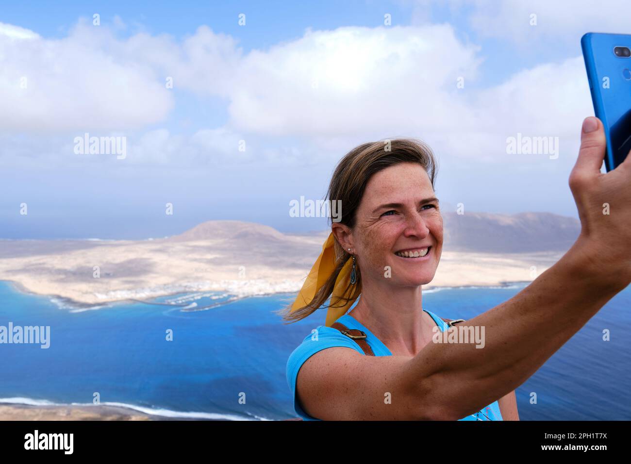 Donna che prende un selfie con la Graciosa Island sullo sfondo. Lanzarote Isole Canarie Foto Stock