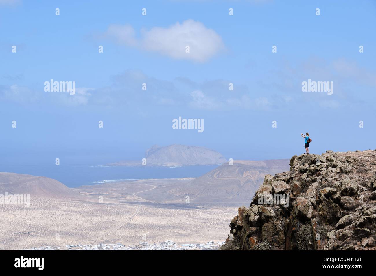 Donna che fotografa il paesaggio da una collina. Isola la Graciosa sullo sfondo. Foto Stock