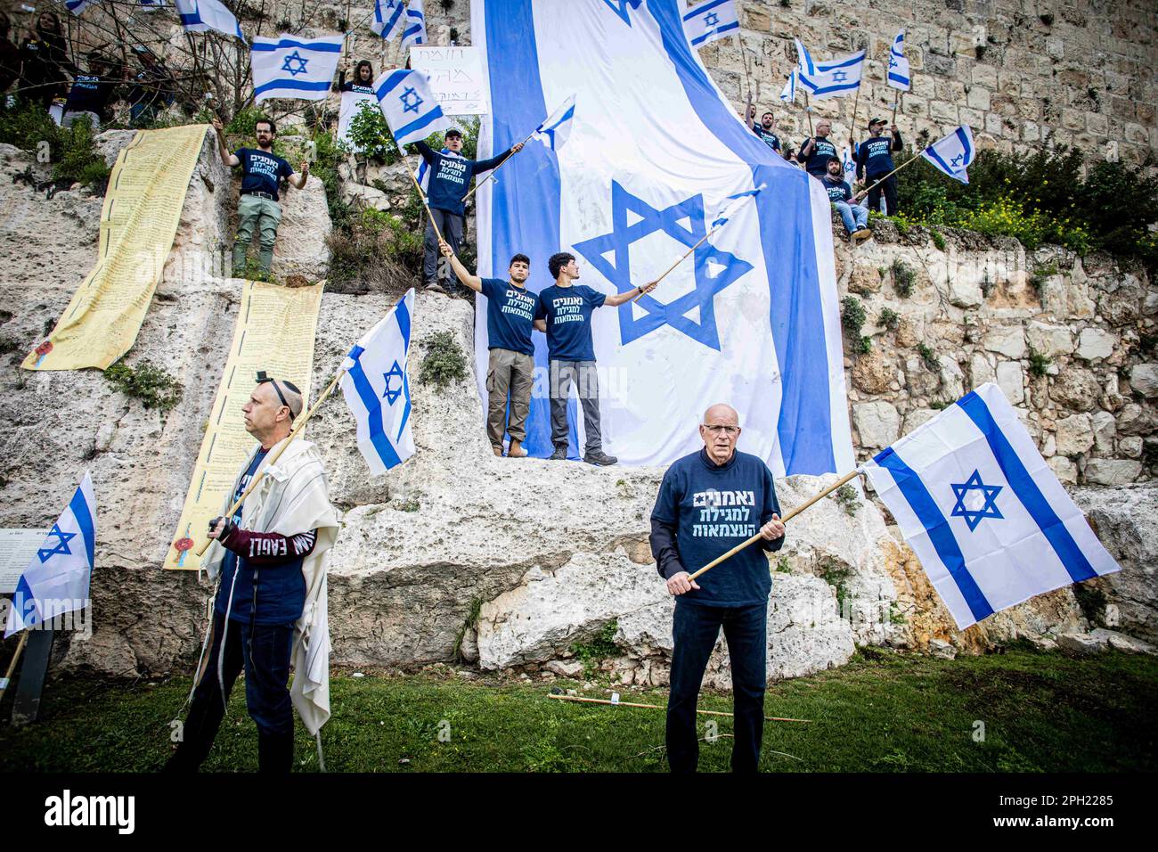 23 marzo 2023, Gerusalemme, Israele: I manifestanti appendono la bandiera israeliana sulla vecchia città murata di Gerusalemme durante una protesta contro la riforma giudiziaria. Il primo ministro israeliano Benjamin Netanyahu Giovedi ha promesso di porre fine alla frattura in una nazione profondamente divisa sulla sua proposta di revisione della magistratura del paese, Netanyahu ha presentato il suo appello in un discorso televisivo nazionale dopo un altro giorno di proteste di massa in tutto il paese contro il piano. I suoi vaghi impegni sono stati rapidamente respinti dal movimento di protesta, che ha detto che avrebbe continuato ad opporsi al tentativo di Netanyahu di diventare un dittatore. (Credit Image: © Foto Stock