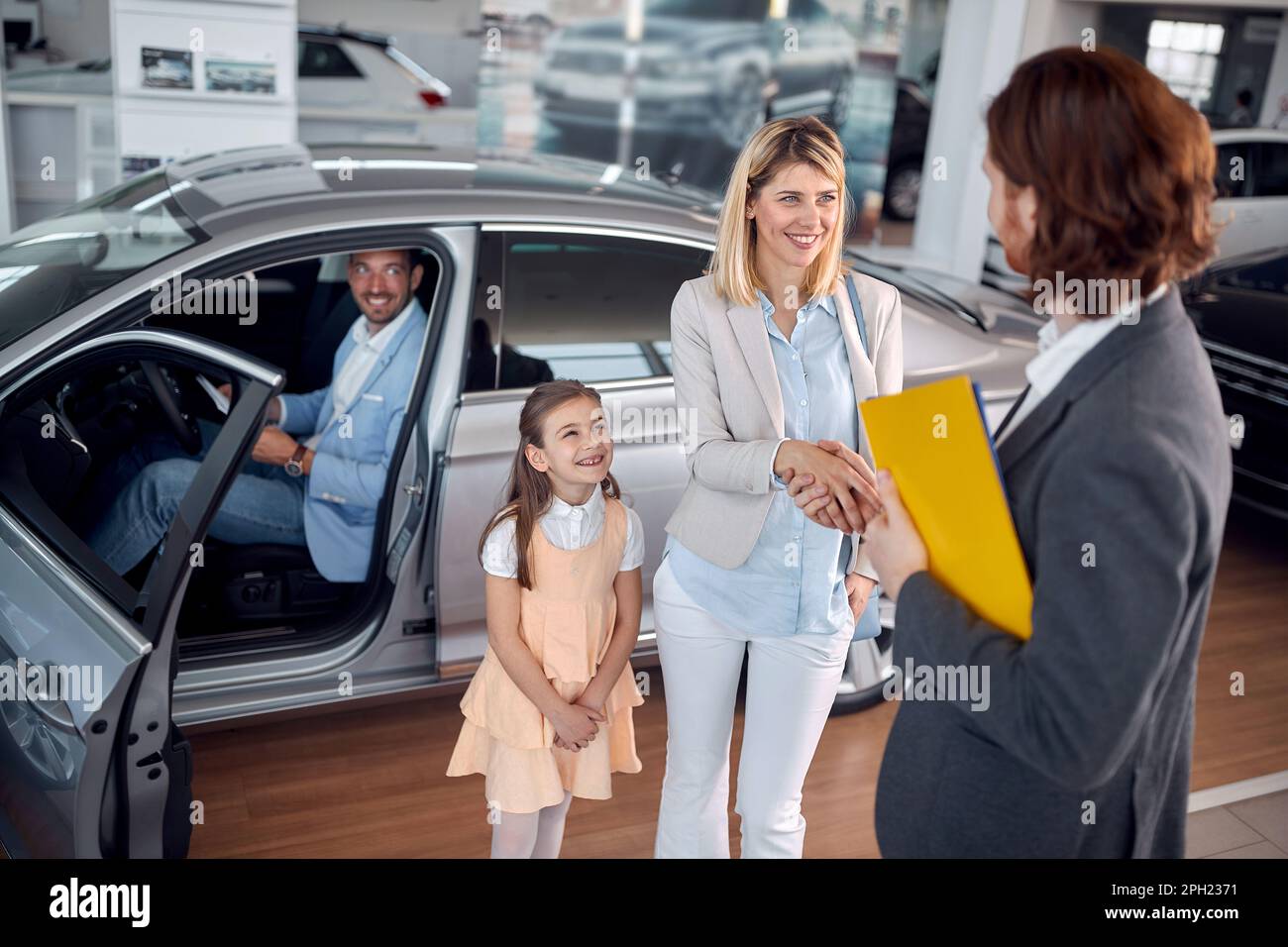 Famiglia yoog felice che compra la nuova automobile nel salone auto Foto Stock