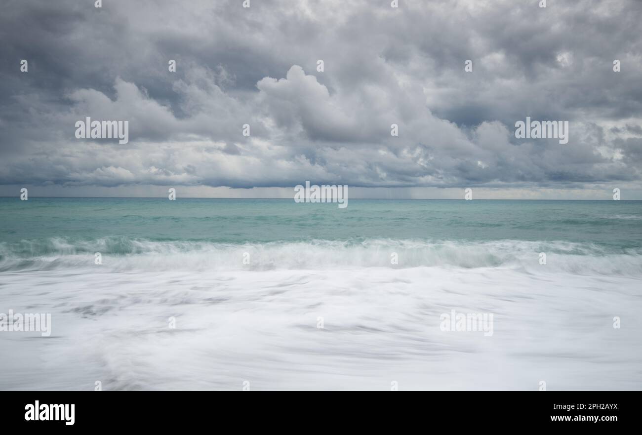 Onde ventose che si infrangono su una costa in una giornata di tempesta in inverno. Foto Stock