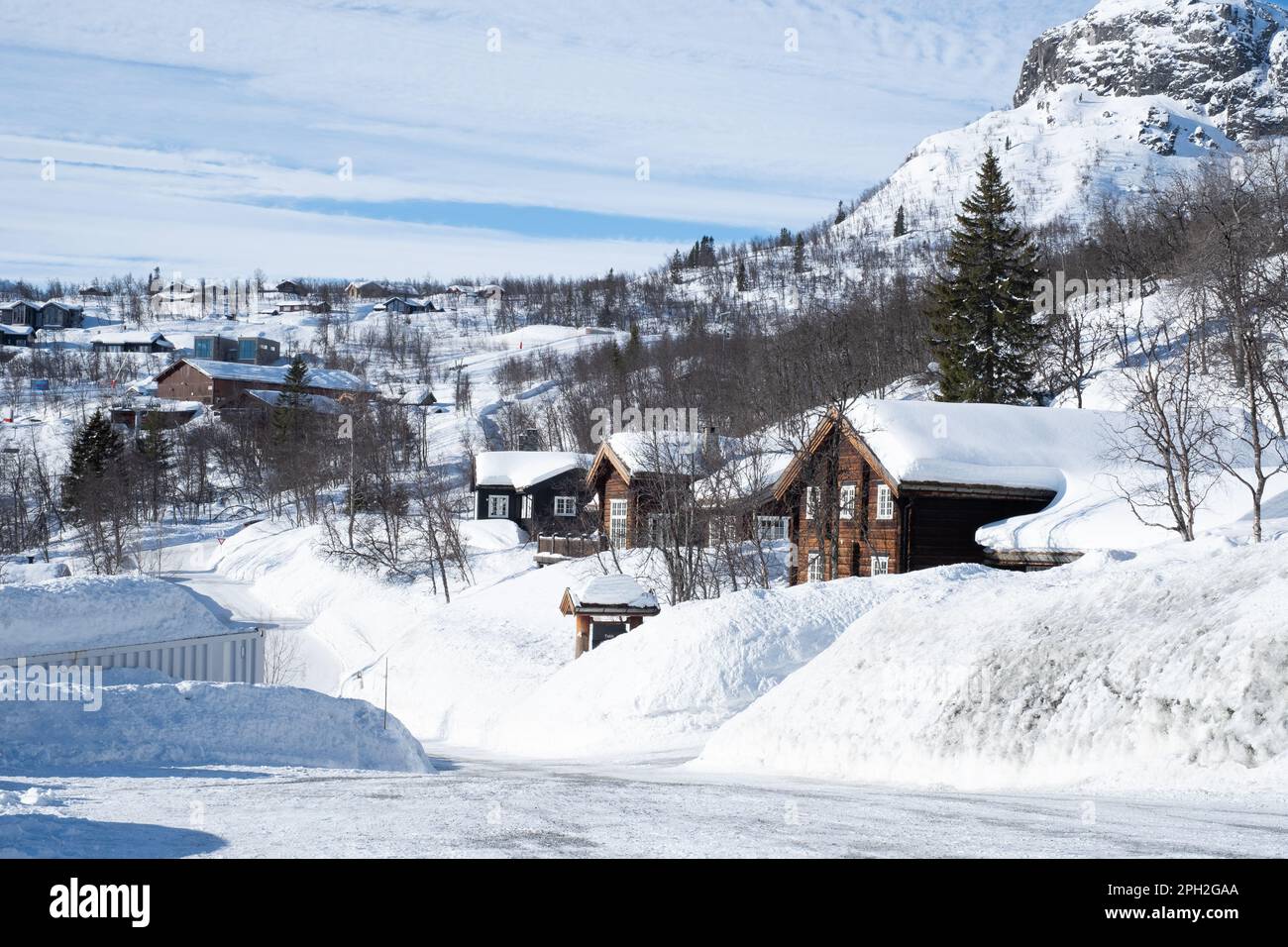 Accogliente cabina in legno sotto la neve in montagna durante l'inverno. Foto Stock