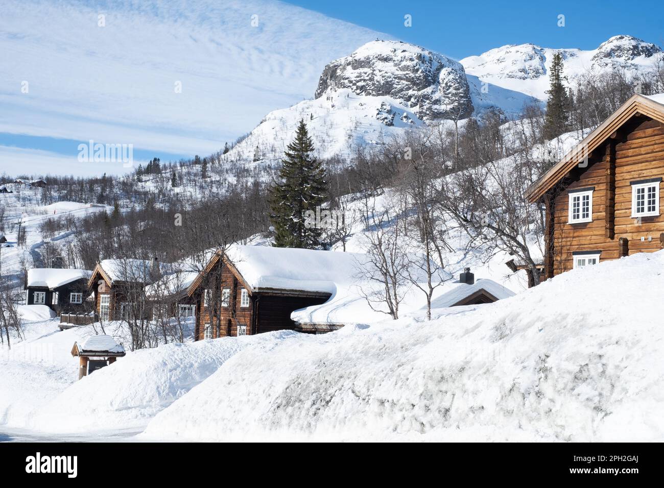 Accogliente cabina in legno sotto la neve in montagna durante l'inverno. Foto Stock