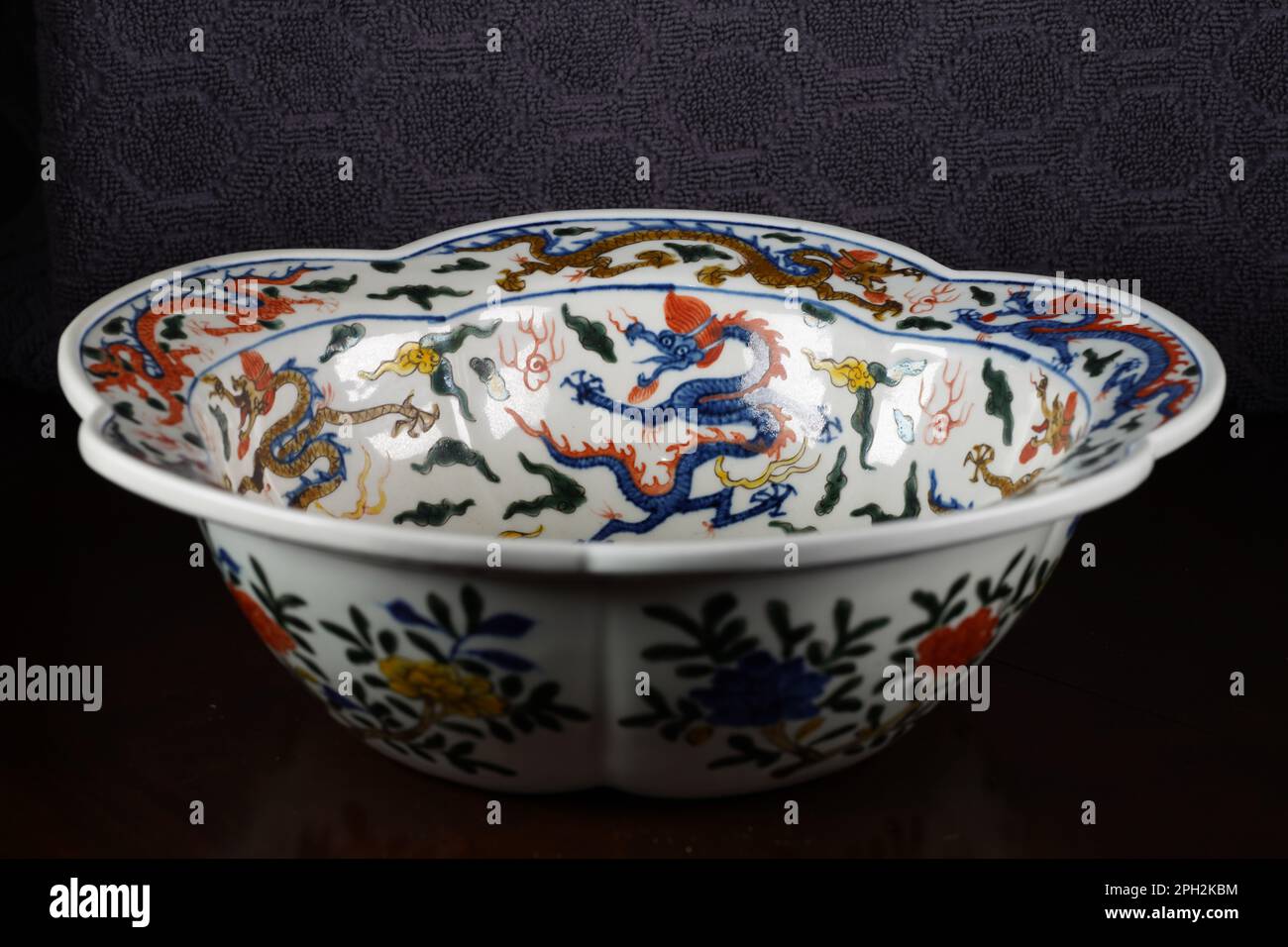 Una ciotola di ceramica bianca su sfondo scuro, con motivi decorativi drago su di essa Foto Stock