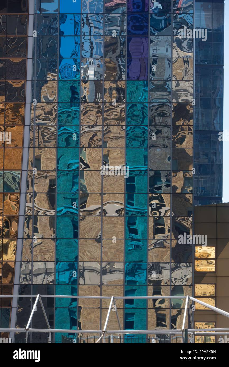 Riflesso astratto l'alto grattacielo si riflette nelle finestre di un edificio adiacente Foto Stock